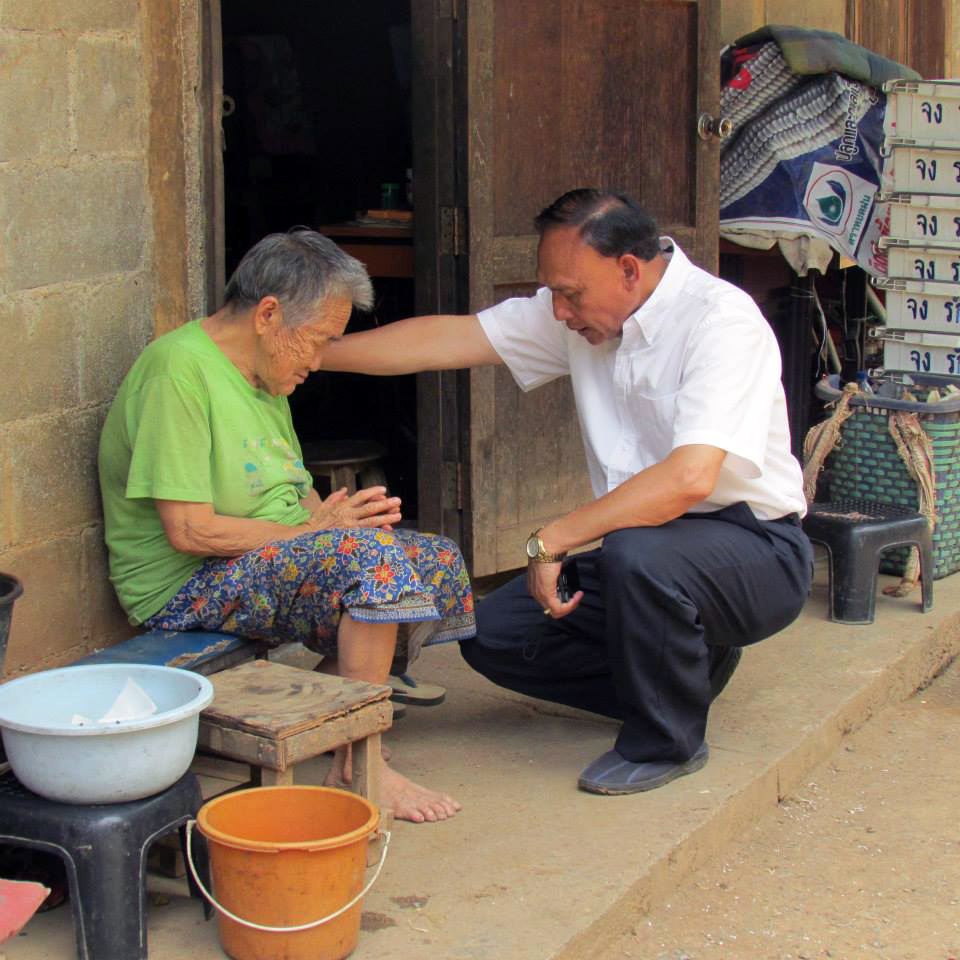 A Yexus Fest ministry leader praying with a woman in Thailand